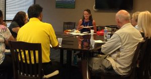 Photo of Kathleen speaking to VI and Blindness group around conference table