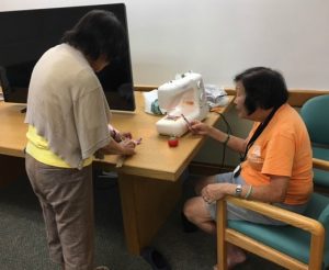 Photo of Elsie getting instructions from Sewing Instructor, Iris