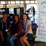 Photo of Julie, Lani, and Kathleen sitting at AILH display table