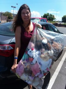 Photo of woman holding bag filled with stuffed animals