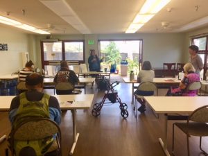 Photo of Hale Kuhao residents seated at tables listening to guest speaker