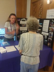 Photo of Kathleen talking to visitor to table