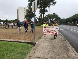 Photo of two ladies carrying banner that reads "Maui Lions Club White Cane Day"