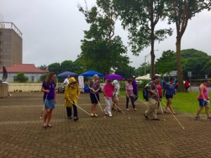 Photo of Kathleen leading participants on white cane walk