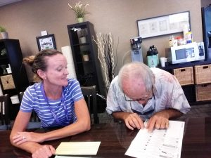 Photo of Kathleen talking to a man looking down at a form