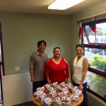 Photo of Tom, Roxanne, and Candice standing with gifts