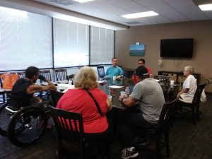 Photo of group sitting around conference table talking