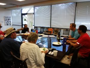 Photo of group sitting around conference table talking