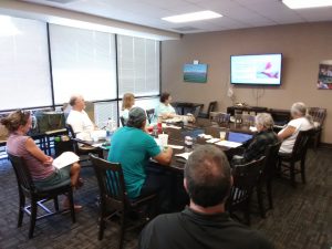 Photo of Maui support group seated around conference table looking at screen