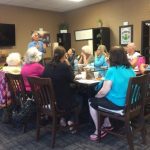 Photo of VIBES group seated around conference table listening to guest speaker