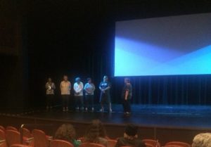 Photo of people standing on stage at movie event